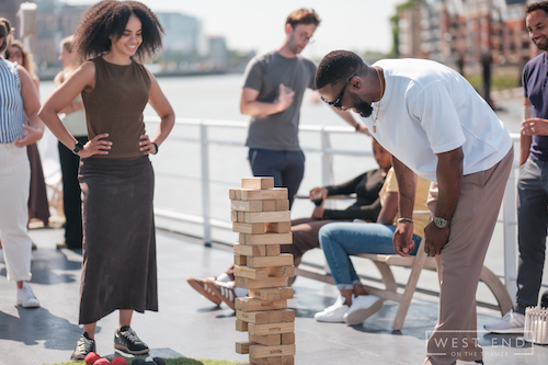 Corporate guests interacting and playing garden games on board, showcasing the "Games on Deck" entertainment for the 2026 season