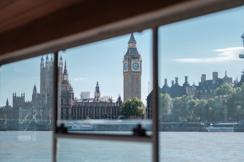 Tranquil interior view of a private Thames vessel showing the calming 'Blue Space' environment for a corporate wellness retreat.